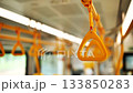 Close-up of an orange handle inside a public transport vehicle, offering stability for commuters 133850283