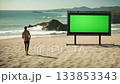 Man Walking on Sandy Beach with Green Screen Billboard in the Background 133853343