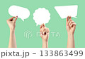 Engaging hands showcase various speech bubbles on a green background for creative communication ideas 133863499