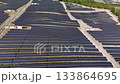 Extensive solar farm with photovoltaic panels covering a vast expanse of land. Aerial footage showcasing clean electricity production 133864695
