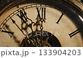 Antique clock face shows hands approaching midnight while golden magic sparks fly around dial; vintage clock marks beginning of New Year celebration during magical midnight moment. 133904203