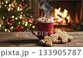 Steaming hot chocolate mug with marshmallows stands on wooden table near gingerbread cookies while hot chocolate warms cozy christmas evening; festive hot chocolate enjoys fireplace background 133905787