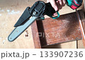 A compact power saw cutting through wood. Symbol of home repair, renovation, or DIY projects. Perfect for construction, crafting, or woodworking themes. Handheld tool precision. 133907236