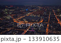 High angle aerial footage capturing the Frankfurt central station, Hauptbahnhof, illuminated at night. Busy streets with traffic and trains leaving 133910635