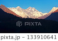 Soft sunlight illuminating snow capped Mount Everest, creating long shadows across rugged Himalayan mountain terrain during dawn's golden hour 133910641