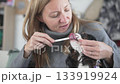 Woman brushing teeth of dog cavalier kings charles spaniel with toothbrush at home 133919924