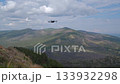 modern remote controlled quadcopter drone flying over scenic mountain landscape. 133932298
