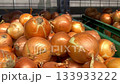Vibrant golden onions are arranged in green crates, emphasizing their rich textures and colors, while the camera smoothly zooms in to capture the freshness and quality of the produce 133933222