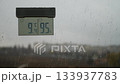 Cloudy weather outside. Rainy weather outside. A thermometer and raindrops on the windowpane. Raindrops on the glass. Cloudy weather outside. Rainy weather outside. A thermometer and raindrops on the windowpane. Raindrops on the glass. 133937783