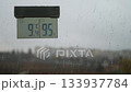 Cloudy weather outside. Rainy weather outside. A thermometer and raindrops on the windowpane. Raindrops on the glass. Cloudy weather outside. Rainy weather outside. A thermometer and raindrops on the windowpane. Raindrops on the glass. 133937784
