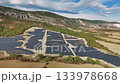 Extensive solar farm covering a hillside, generating sustainable and eco friendly electricity. Modern photovoltaic panels producing clean power 133978668