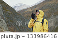 Hiker talking on walkie-talkie in mountains 133986416