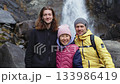 Group of happy friends smiling in front of a waterfall 133986419
