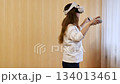 Woman Playing Virtual Reality Game with Controllers 134013461