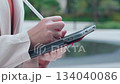 Close up hand young businesswoman writing on digital tablet in city. 134040086