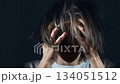 Teenager shaking head and nervously touching hair feeling depression and emotional overload. Young person grabbing head experiencing rising tension and overwhelming stress. Adolescent moving head 134051512