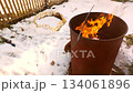 Winter backyard fire in a metal burn barrel bright flames and smoke on snow controlled burning of yard debris clip for cleanup homestead and maintenance b roll 134061896