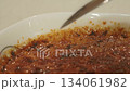 Spoon taps the caramelized crust of creme brulee and scoops custard appetizing texture crunch and sugar shine versatile food shot for menus food blogs ads restaurants and recipes 134061982