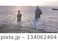 Two brothers are fishing on the seashore with fishing rods 134062404