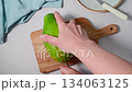 female hands cutting Papaya orange fruit halves, bright background 134063125