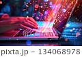 A person is actively typing on a sleek laptop, surrounded by vibrant digital particles that create a sense of movement and energy, reflecting a busy technological atmosphere. A person is actively typing on a sleek laptop, surrounded by vibrant digital particles that create a sense of movement and energy, reflecting a busy technological atmosphere. 134068978
