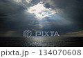 Rain in sea. Rain falling in sea. Cloudy, rainy, stormy weather at sea. Dark rainy clouds over water. Sea, sky, clouds and horizon line. Seascape. Scenery landscape. The sun shining through the clouds 134070608