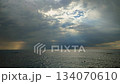 Rain in sea. Rain falling in sea. Cloudy, rainy, stormy weather at sea. Dark rainy clouds over water. Sea, sky, clouds and horizon line. Seascape. Scenery landscape. Nature natural background 134070610