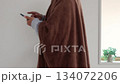 着る毛布を着てスマートフォンを使う男性（30代、日本人、顔無し） 134072206