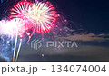 Colorful fireworks lighting up the night sky above an urban city skyline, creating a festive and celebratory atmosphere 134074004