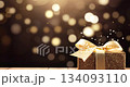 golden gift box with a bow on wooden table on festive glittering dark black bokeh background 134093110