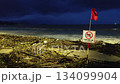 Rainy season storm damage on Nha Trang beach with No Swimming warning sign 134099904