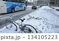 Winter road conditions in central Sapporo. Cars driving on slushy snow and abandoned bicycles buried in the snow. 134105223