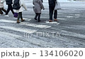 The feet of people walking on a crosswalk in Sapporo in winter. A scene of people commuting to work on a frozen, slushy snow road. 134106020