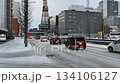 Sapporo TV Tower and winter road conditions. Cars driving on a slushy snowy road and the streets around Odori Park. 134106127