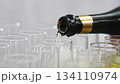 Champagne from the bottle is poured into glasses.  134110974