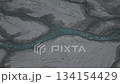 Aerial view of winding river flowing through sandy terrain with motion 134154429