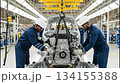 Workers carefully guide a large car engine into its final position on the assembly line in a Brazilian automobile factory. This shows the precise steps in engine installation. 134155388