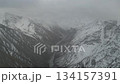 Aerial view of snow-covered mountains with river flowing through valley 134157391