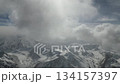 Aerial view of majestic snow-covered mountains with dynamic cloud movement 134157397