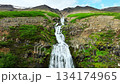 Scenic Mountain Waterfall Flowing Through Rocky Green Landscape 134174965