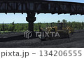 Aerial view of bulldozers moving and directing coal at thermal power plant during daytime operations 134206555