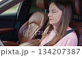 Worried woman in car waves hands in distress, suffering from shortness of breath, panic attack, tachycardia, and stress while sitting in the driver seat. Breathing issues 134207387