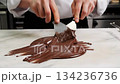 Chocolatier spreads and works hot dark chocolate on a marble slab in a close up timelapse. Watch the process of creating smooth, tempered chocolate unfold. 134236736