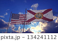 Waving United States and Florida State Flags Against a Dramatic Sunset Sky 134241112