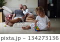 Small baby girl playing toys with her parents on the background at home 134273136