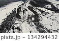 Aerial drone flight over a snowy mountain ridge in a dramatic winter landscape, showcasing 134294432