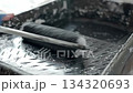 Paint roller covered with black paint in tray 134320693