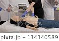 Medical students practicing defibrillation on a dummy 134340589