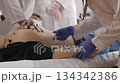 Medical students practicing cpr and iv injection on a dummy 134342386