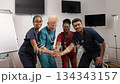 Diverse medical team celebrating success together in hospital 134343157
